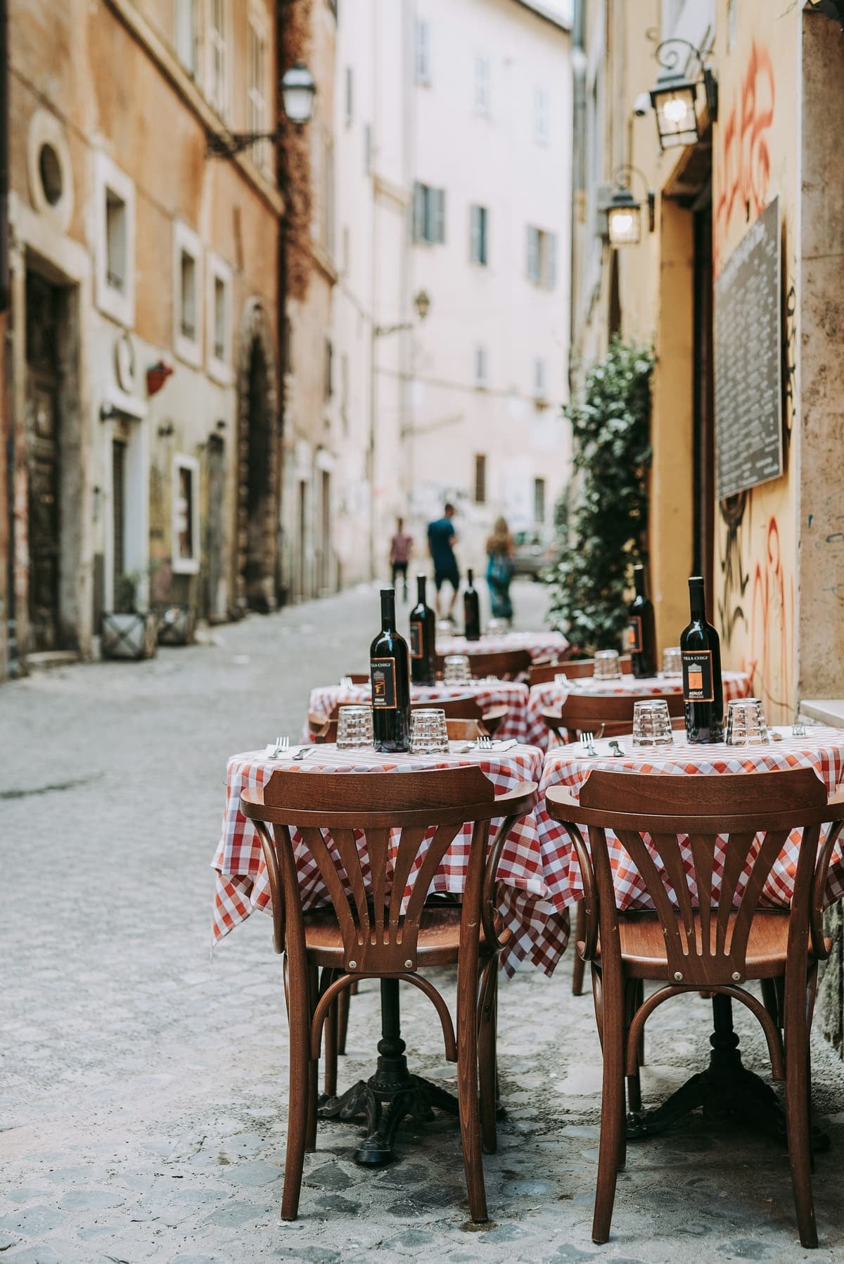 Une table nappée de carreaux rouges dans une ruelle de Rome