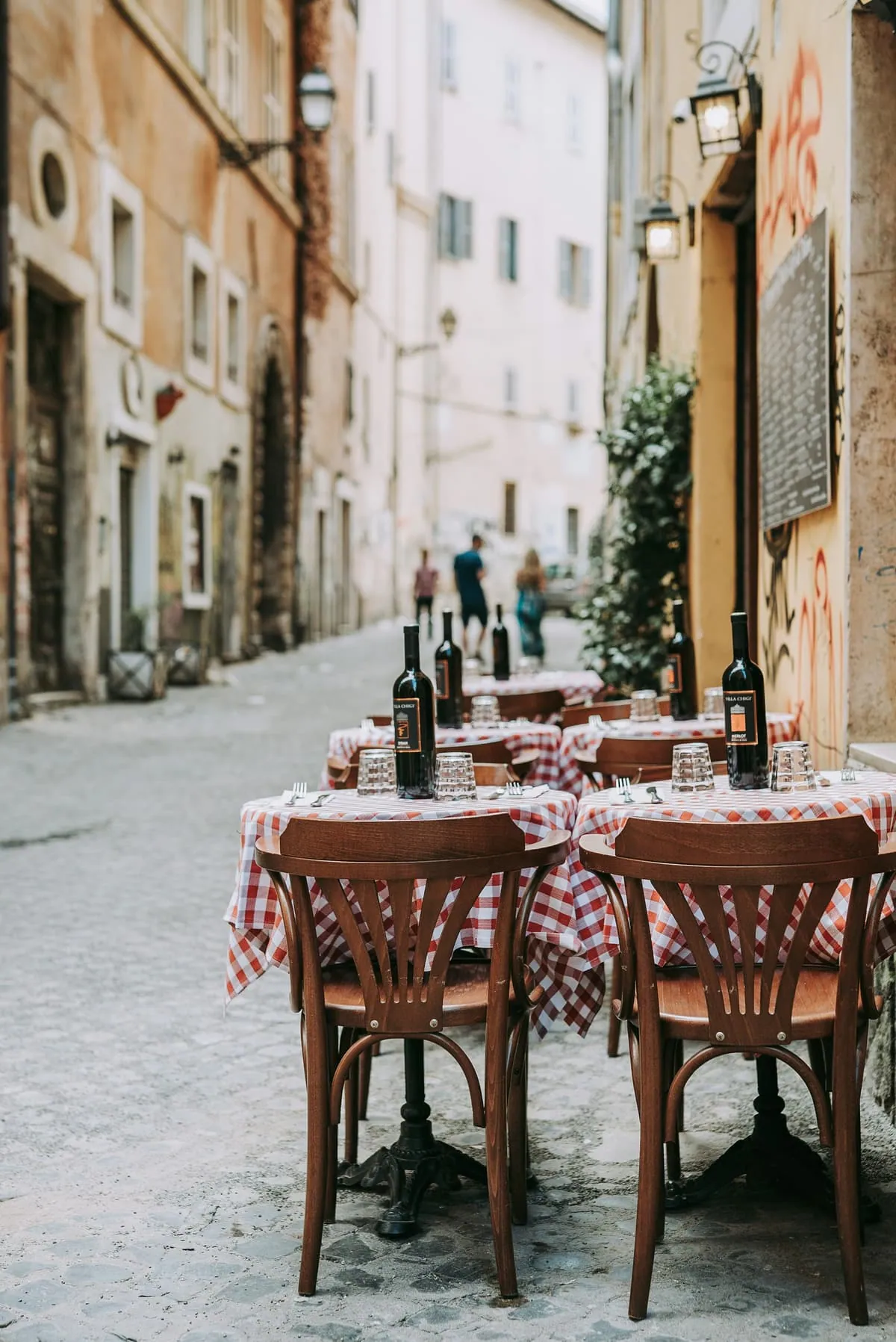 Une table nappée de carreaux rouges dans une ruelle de Rome