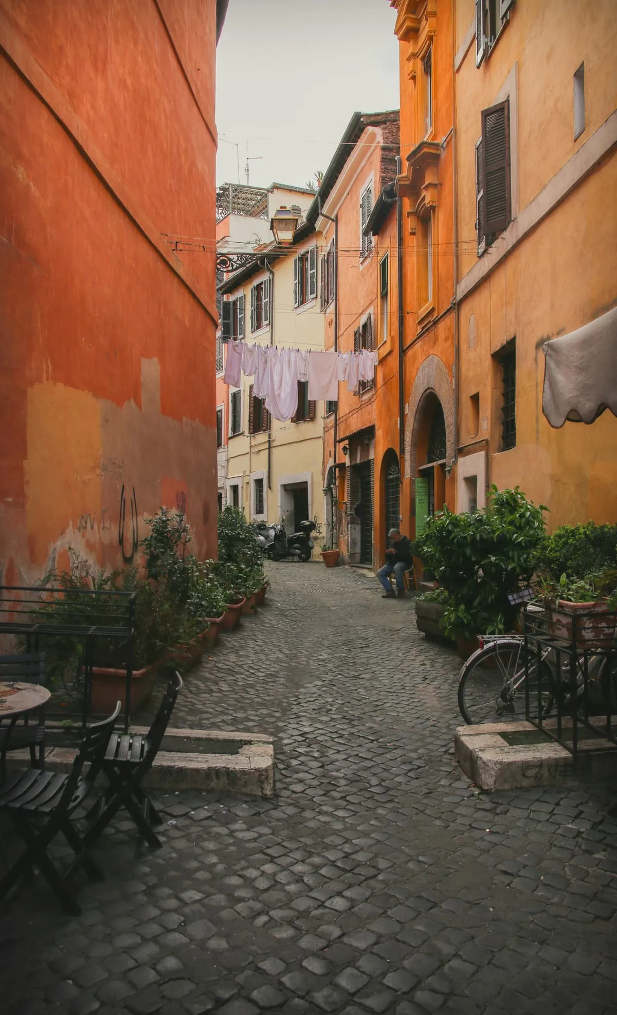 Une ruelle de Rome aux façades orangées et aux plantes vertes